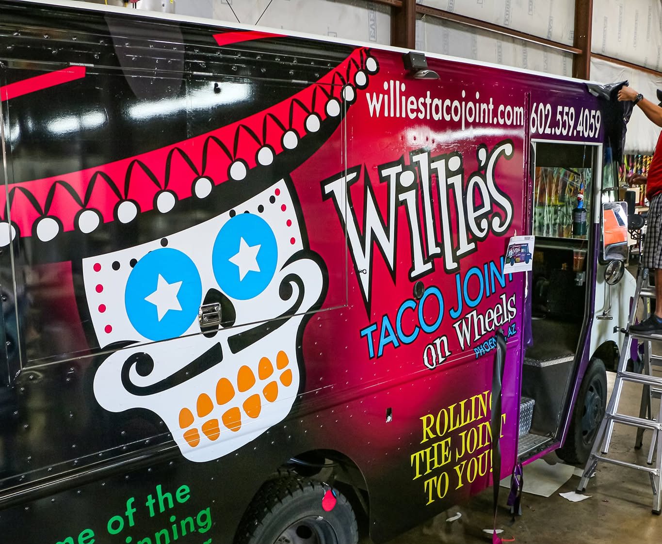 A&M Graphics installer finishing Willie's Taco Joint food truck wrap